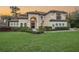 Elegant two-story home featuring a tile roof, manicured landscaping, and arched entryway at 5914 Fitzgerald Rd, Odessa, FL 33556