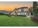Beautiful home at sunset boasts lush lawn, mature landscaping, and grand architectural details at 5914 Fitzgerald Rd, Odessa, FL 33556