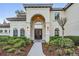 Close up view of home's entry with an arched entry, double doors, and beautiful landscaping at 5914 Fitzgerald Rd, Odessa, FL 33556