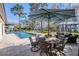 Spacious outdoor dining near the refreshing pool and a serene lake view at 5914 Fitzgerald Rd, Odessa, FL 33556