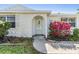 Close up of the home's front entrance showcasing the stone facade and colorful plantings at 6214 Westport Dr, Port Richey, FL 34668