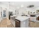 Open concept kitchen with stainless steel appliances, farmhouse sink, and view of the living room and fireplace at 7122 Bowspirit Pl, Apollo Beach, FL 33572