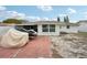 The backyard shows the home's exterior and a covered boat with a red brick patio at 7740 Bracken Dr, Port Richey, FL 34668