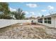 Wide-open backyard featuring white fencing, brick patio and room for boat parking, adjacent to house and Florida room at 7740 Bracken Dr, Port Richey, FL 34668