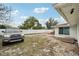 Open backyard, featuring boat on brick patio and car parked near white fence, providing ample space and parking at 7740 Bracken Dr, Port Richey, FL 34668