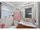 Bright bathroom features a large window, neutral walls, and a functional sink with a medicine cabinet mirror at 7740 Bracken Dr, Port Richey, FL 34668