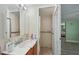 Bathroom with vanity and sink, tile shower, and access door leading to a main bedroom at 7740 Bracken Dr, Port Richey, FL 34668