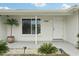 Home entrance with manicured landscaping, decorative plants and house number prominently displayed beside entry door at 7740 Bracken Dr, Port Richey, FL 34668