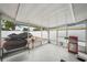 The covered patio features an outdoor grill, wicker furniture, and a view of the backyard at 7740 Bracken Dr, Port Richey, FL 34668