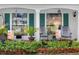 Charming front porch with seating and decorative plants, enhancing the home's curb appeal at 8216 Mill Creek Ln, Hudson, FL 34667