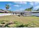 Expansive backyard featuring a screened pool, lush lawn, mature palm trees, and fenced perimeter at 8942 Aberdeen Creek Cir, Riverview, FL 33569