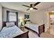 This is a secondary bedroom with two twin beds, a ceiling fan, and an ensuite bathroom at 8942 Aberdeen Creek Cir, Riverview, FL 33569
