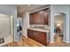 Hallway pantry space featuring dark wood cabinets with granite countertops and wood floors at 8942 Aberdeen Creek Cir, Riverview, FL 33569