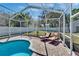 Relaxing screened-in pool area with brick pavers, lush landscaping and lounge seating at 8942 Aberdeen Creek Cir, Riverview, FL 33569