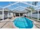 Relaxing screened-in pool area with lush landscaping, brick pavers and a backyard view at 8942 Aberdeen Creek Cir, Riverview, FL 33569
