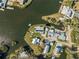 Aerial view of a waterfront community with docks, green yards, and lush vegetation around the river at 9017 Petal Ct, Hudson, FL 34667
