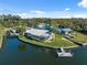 Aerial view of waterfront house with dock, surrounded by lush greenery and serene water at 9017 Petal Ct, Hudson, FL 34667