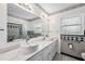 Bathroom with dual sinks, seashell wallpaper, tub and shower combo and updated tile at 9017 Petal Ct, Hudson, FL 34667