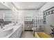 Bathroom with dual sinks, seashell wallpaper, tub and shower combo and updated tile at 9017 Petal Ct, Hudson, FL 34667