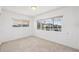 Bright bedroom with terrazzo floors and two windows offering plenty of natural light at 9017 Petal Ct, Hudson, FL 34667