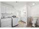 Laundry room with white cabinets, appliances, access to the bathroom, and outside entry at 9017 Petal Ct, Hudson, FL 34667