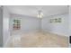 Airy bedroom featuring travertine floors, ample natural light, and decorative ceiling fan at 902 Marco Ne Dr, St Petersburg, FL 33702