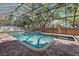 Sparkling screened pool with waterfall feature and brick paver deck surrounded by mature landscaping at 902 Marco Ne Dr, St Petersburg, FL 33702
