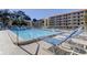 Community pool with lounge chairs and access to residential buildings, a perfect place to relax and unwind at 9433 Harbor Greens Way # 405, Seminole, FL 33776