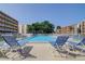 Beautiful community pool featuring lounge chairs, clear blue water, and surrounding residential buildings at 9433 Harbor Greens Way # 405, Seminole, FL 33776