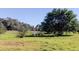 Scenic outdoor view with pond, mature trees, and lush greenery, a serene setting for relaxation and enjoyment at 9433 Harbor Greens Way # 405, Seminole, FL 33776