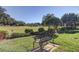 Inviting outdoor space with lush landscaping, mature trees, and a charming bench overlooking the golf course at 9433 Harbor Greens Way # 405, Seminole, FL 33776