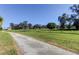 Picturesque outdoor view with a private road, lush greenery, mature trees, and ample space for outdoor activities at 9433 Harbor Greens Way # 405, Seminole, FL 33776
