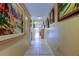 Inviting hallway with tile flooring, decorative paintings and closet leading to bright, sunlit room at 9433 Harbor Greens Way # 405, Seminole, FL 33776