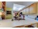 Well-lit kitchen featuring ample counter space, light wood cabinetry, and view into dining room at 9433 Harbor Greens Way # 405, Seminole, FL 33776
