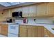 Bright kitchen featuring white appliances, light wood cabinetry, and neutral countertops at 9433 Harbor Greens Way # 405, Seminole, FL 33776