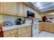 Well-equipped kitchen offering white appliances, light wood cabinets, and white countertops at 9433 Harbor Greens Way # 405, Seminole, FL 33776