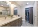 Bathroom with double vanity, large mirror and a shower with a glass enclosure plus view of closet at 9730 Lake Chase Island Way # 9730, Tampa, FL 33626