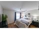 Cozy bedroom featuring hardwood floors, a ceiling fan, and bright natural light from the window at 9730 Lake Chase Island Way # 9730, Tampa, FL 33626