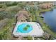 Aerial view of an octagon-shaped pool and spa surrounded by palm trees and lush landscaping at 9730 Lake Chase Island Way # 9730, Tampa, FL 33626