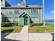 Green two-story townhome with a well-maintained lawn and walkway leading to the front door by the water at 9730 Lake Chase Island Way # 9730, Tampa, FL 33626