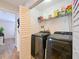 Convenient laundry room featuring side by side washer and dryer and storage shelves at 9730 Lake Chase Island Way # 9730, Tampa, FL 33626