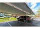 Reserved covered parking space with surrounding green space and nearby apartment buildings at 9730 Lake Chase Island Way # 9730, Tampa, FL 33626