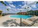 Poolside view, with lounge chairs and palm trees. Townhomes in the background at 9730 Lake Chase Island Way # 9730, Tampa, FL 33626