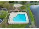 Aerial view of a well-maintained community pool with a charming cabana and nearby volleyball court at 9730 Lake Chase Island Way # 9730, Tampa, FL 33626
