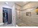 Close up of tiled shower with glass enclosure and niche for toiletries plus view of closet with curtain at 9730 Lake Chase Island Way # 9730, Tampa, FL 33626