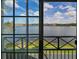 Balcony view showcasing a picturesque lake and community landscape through a screened window at 9730 Lake Chase Island Way # 9730, Tampa, FL 33626