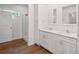 Bathroom featuring double sink vanity with quartz countertops, white cabinets and framed mirrors, and a glass door shower at 1001 Newton S Ave, St Petersburg, FL 33705