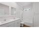 Bathroom featuring a double sink vanity with quartz countertops, white cabinets and framed mirrors, tub and shower at 1001 Newton S Ave, St Petersburg, FL 33705