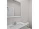 Bathroom sink with quartz countertop, white cabinet, framed mirror, toilet and towel rack at 1001 Newton S Ave, St Petersburg, FL 33705