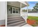 Charming front porch with gray stairs, white railings, and a view of the street at 1001 Newton S Ave, St Petersburg, FL 33705